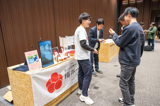本会場の隣にある展示エリアで、和歌山県の「梅ボーイズ」が梅酢などの自社製品をPRする様子