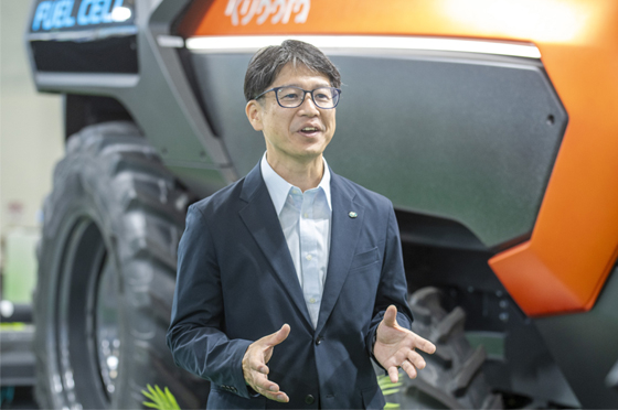 オートノマスFCトラクタの横で説明をするクボタの南出さん