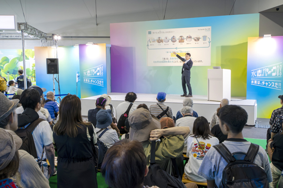特別ステージで来場者に向け、クボタの取り組みとオートノマスFCトラクタについて説明するクボタの南出さん