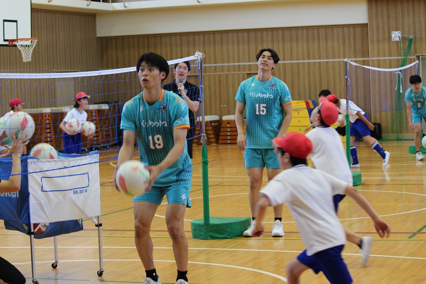 クボタスピアーズの選手が小学生にトスをあげている様子